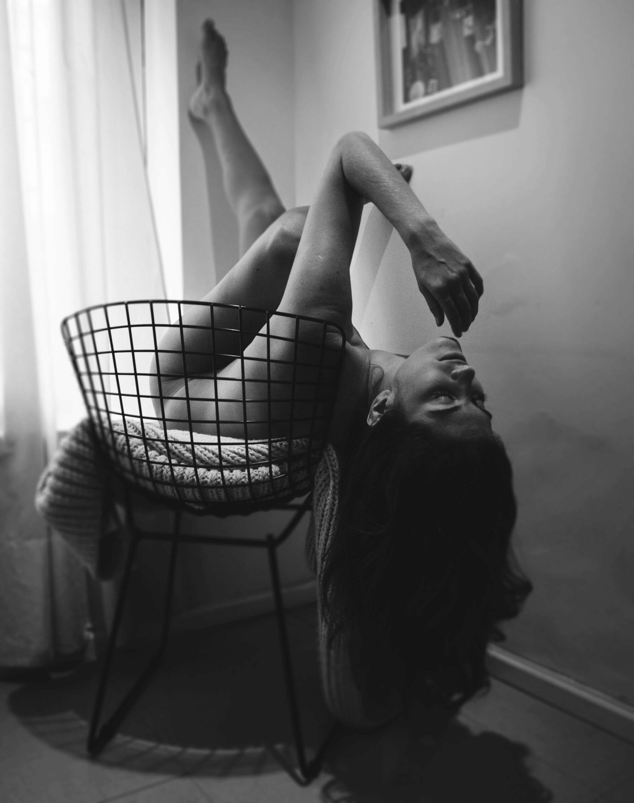 A Webcam Model poses on a chair